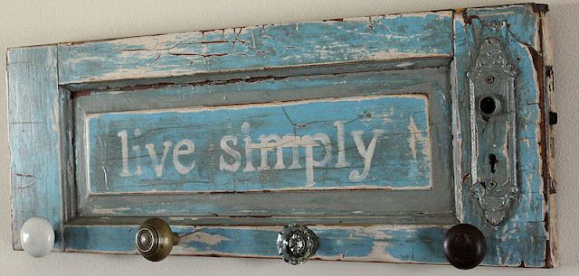 Old cabinet door repurposed to a coat hanger. Love this color, quote and knobs for