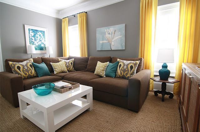 brown, gray, teal and yellow living room with sectional sofa and white coffee table