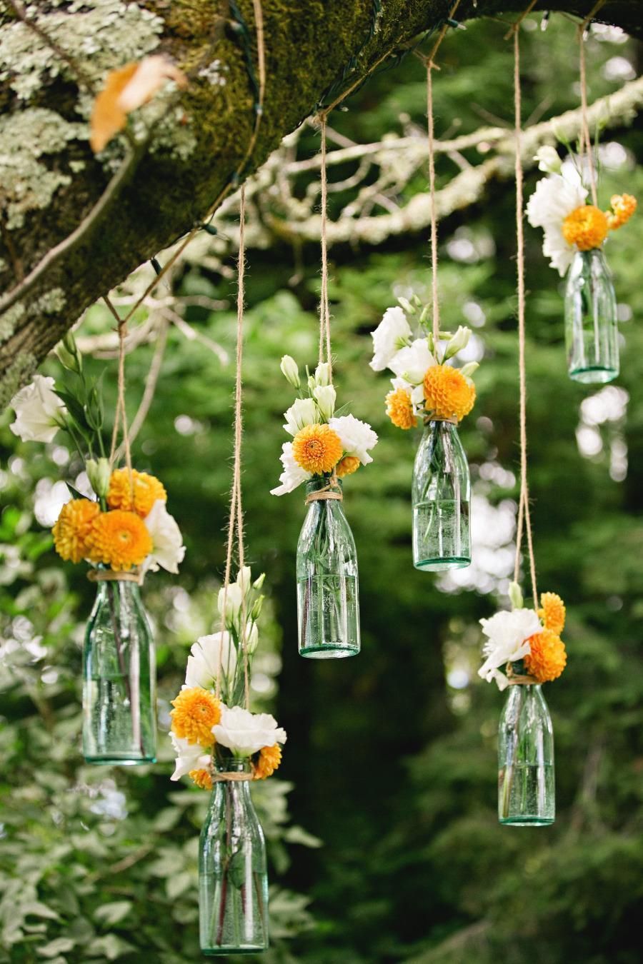 hanging flowers for outdoor wedding ceremony / reception decor. Suspend clear soda bottles from tree branches with jute / rustic