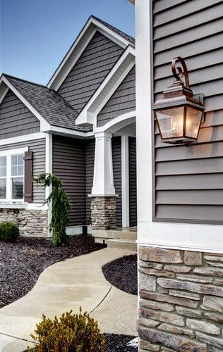 Love the colors, stone & oil bronzed light fixtures with the pops of white trim. Just love. And the black mulch is a great