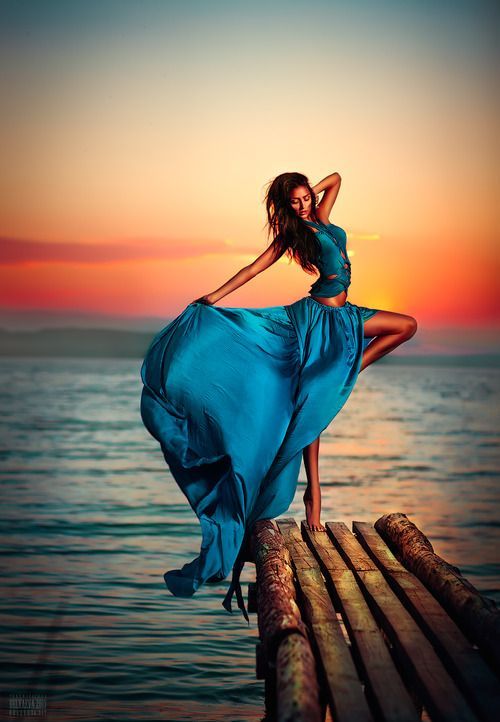 Awesome picture! Blue long dress in petrol on a landing stage with a Sunset!
