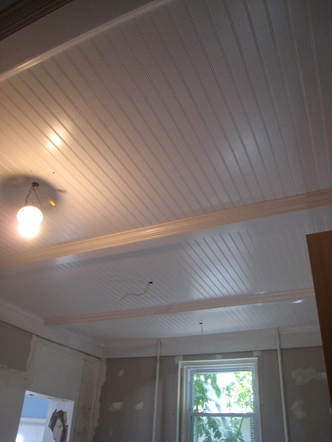 basement ceiling idea. remove drop ceiling, paint beams white and put up bead board panels between beams.