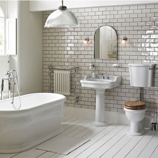 One of the most stunning bathrooms with a large bath tub, a basin with a full length pedestal and a close compact toilet with soft