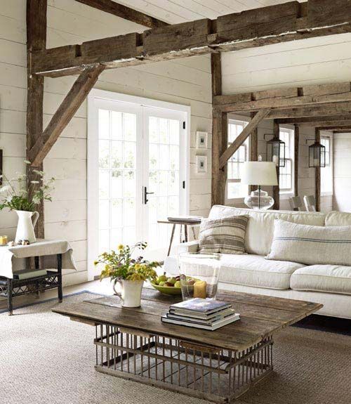 This living room employs clean, modern touches in order to enliven an aged farmhouse interior. A Pottery Barn sofa slipcovered in
