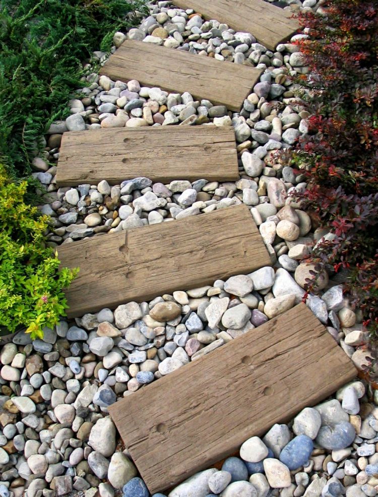 Weg im Garten – Balken aus Treibholz dienen als Trittplatten und sind mit Kies umrahmt
