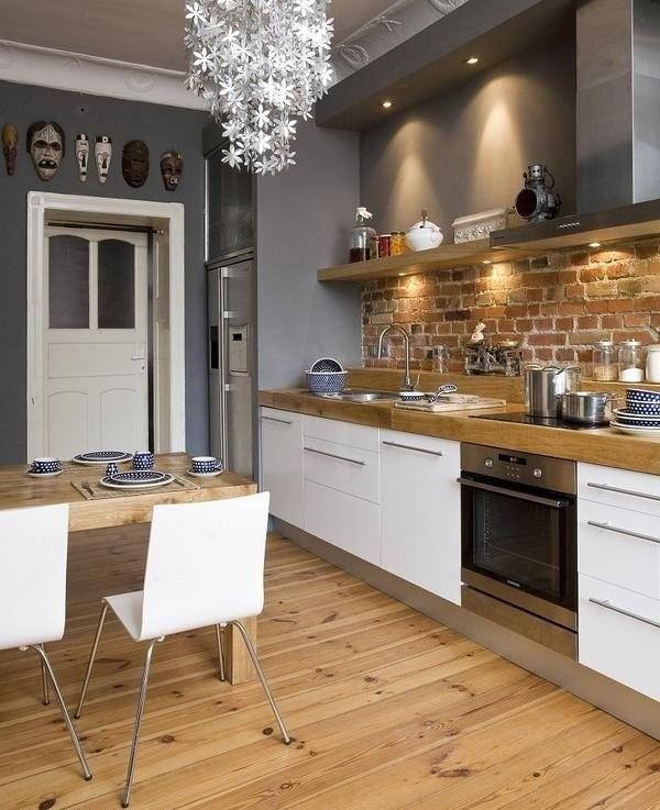 white grey kitchen with exposed brick and natural wood.