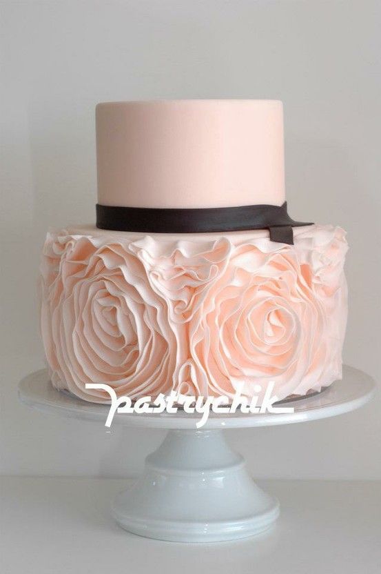 Beautiful blush pink 2-tiered cake with contrasting layers. Separated by a thin chocolate brown ribbon, the 1st tier is smooth