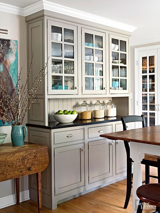 Built-in custom cabinets get a sleek neutral finish from a coat of gray color. The pleasing blend of traditional cabinetry with