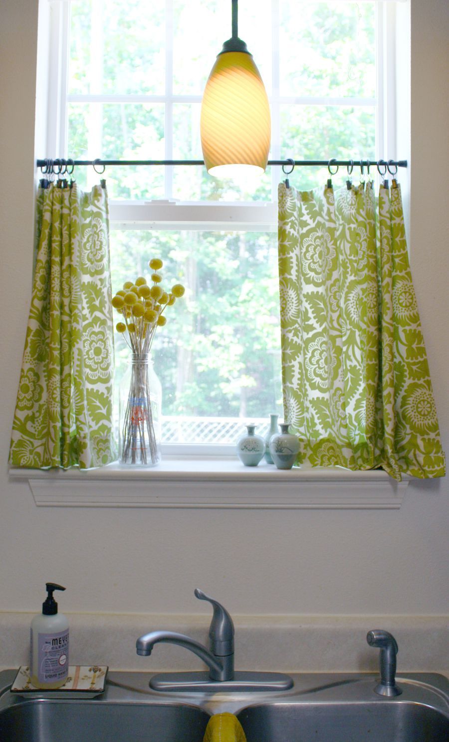 Kitchen cafe curtains with a tension rod and curtain clips. The blog also has a link to an amazing idea for window treatments for