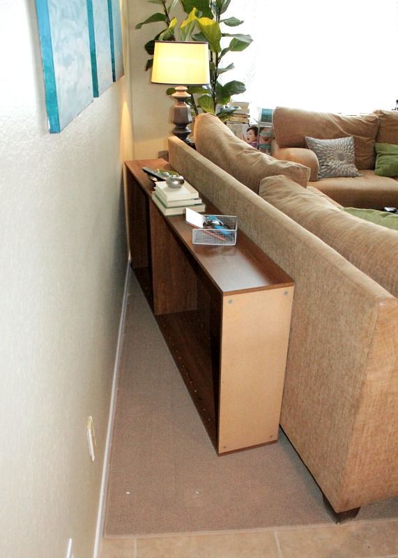 Upcycle a bookcase into a behind the couch table, then just push the case & couch up against the wall!