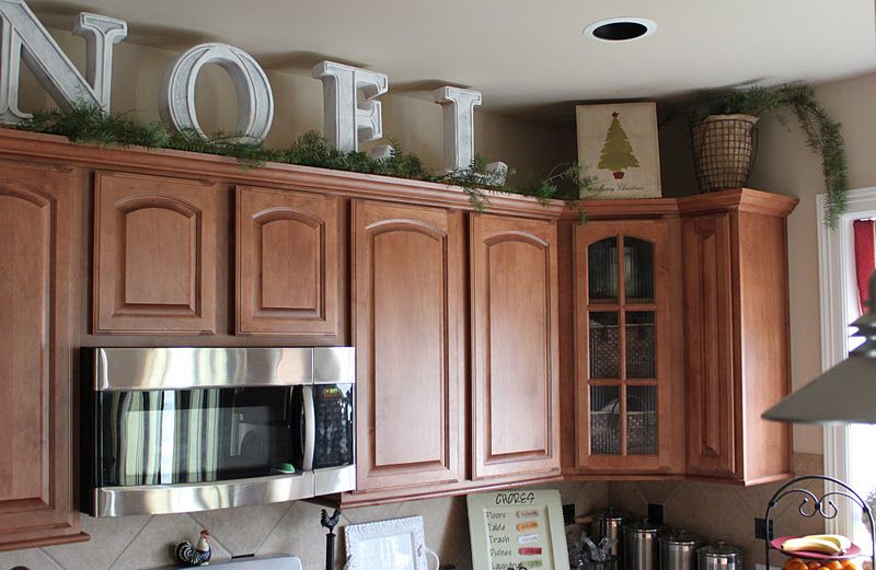Big letters and pine garland above the kitchen cabinets