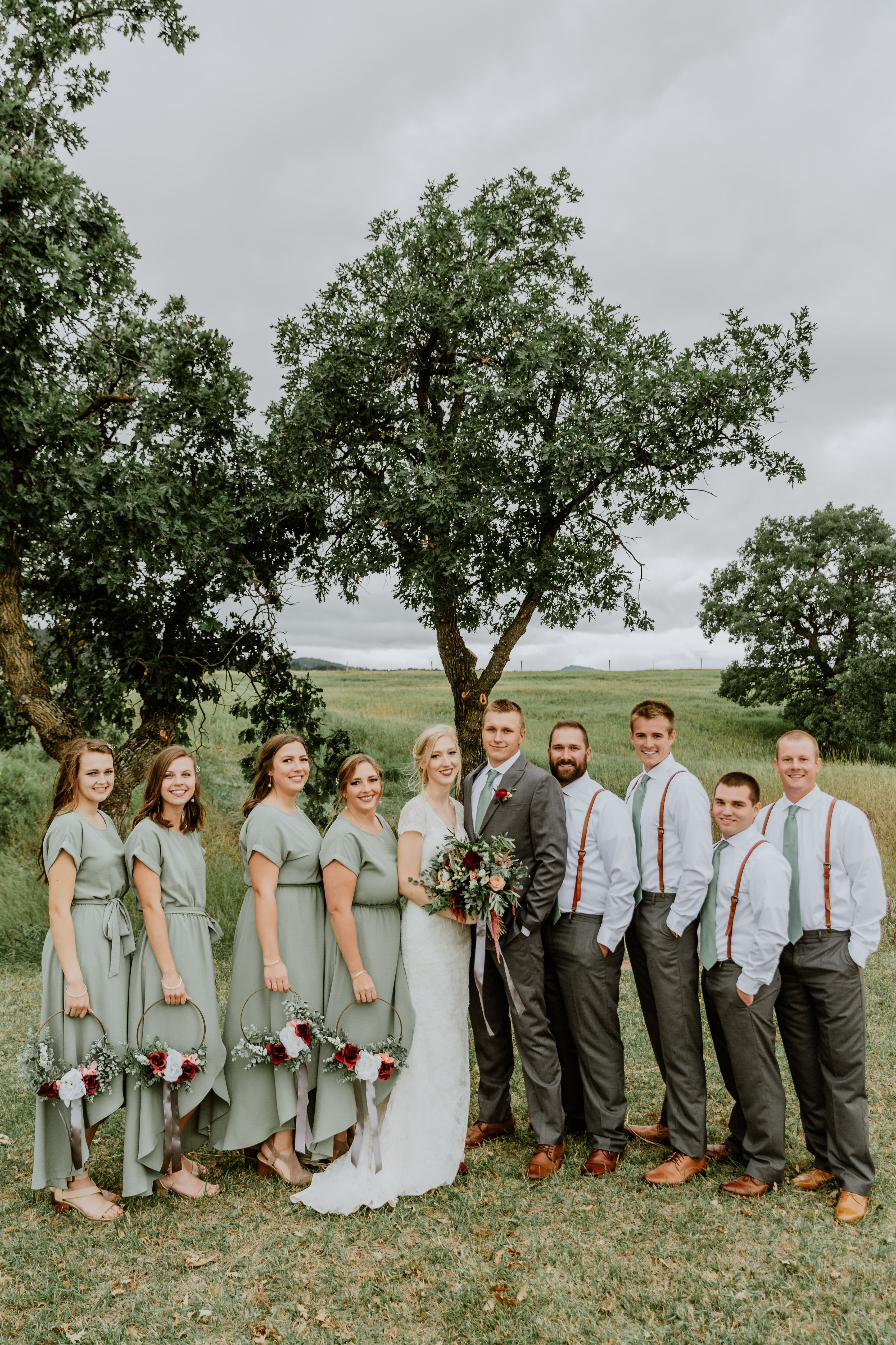 Bridal party wearing sage green dresses and suspenders at an outdoor summer wedding -   17 sage green wedding party ideas