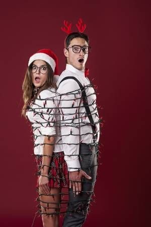 Funny nerd couple are tangling  in christmas lights -   17 christmas photoshoot couples funny ideas